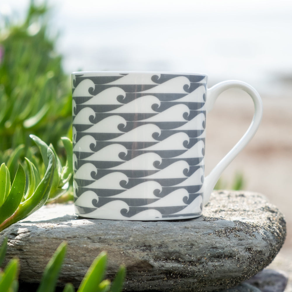 Mug with Grey wave pattern on a rock with greenery