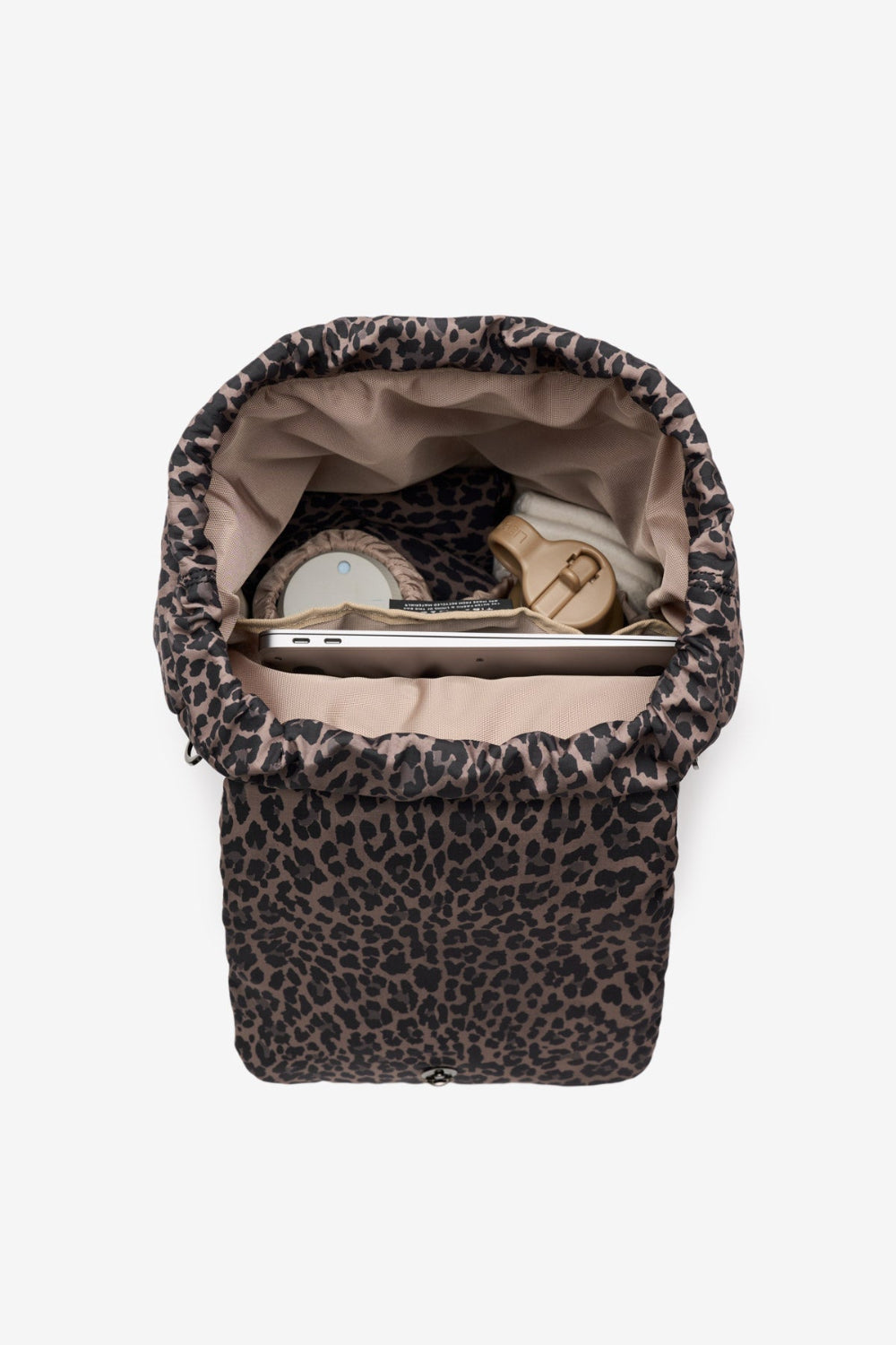 Leopard print baby carrier with items inside on a white background