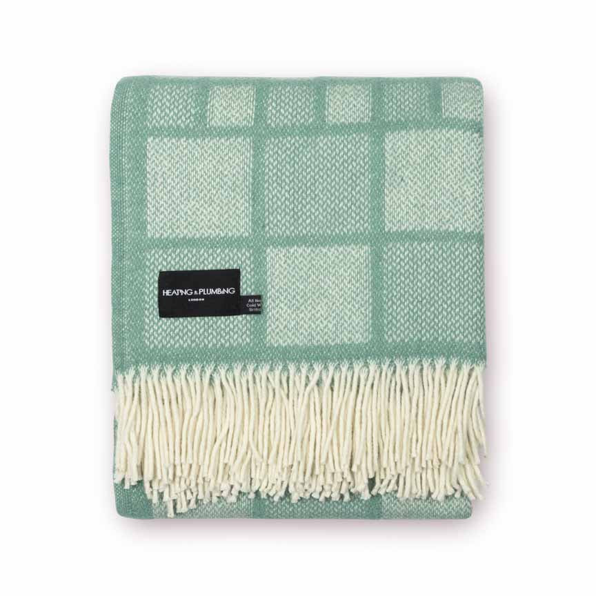 Green checkered throw blanket with white fringe on a white background
