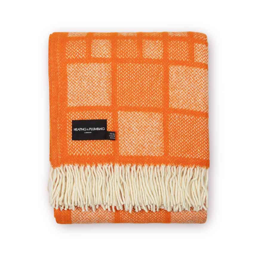 Orange checkered blanket with white fringe on a white background