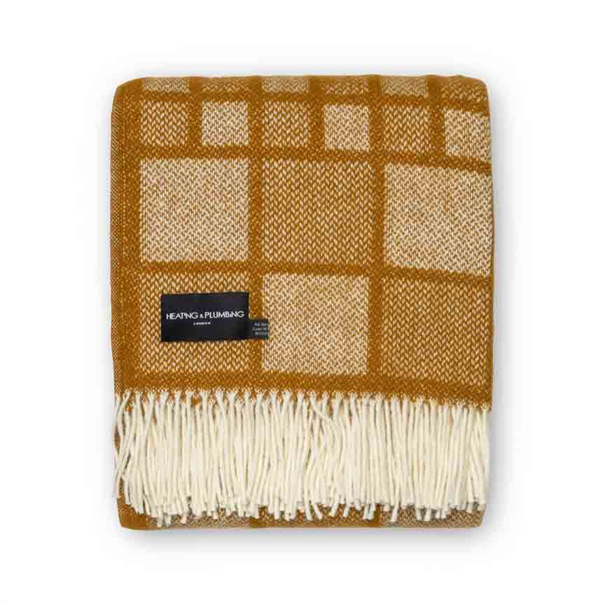 Plaid blanket with brown and beige squares and white fringe on a white background