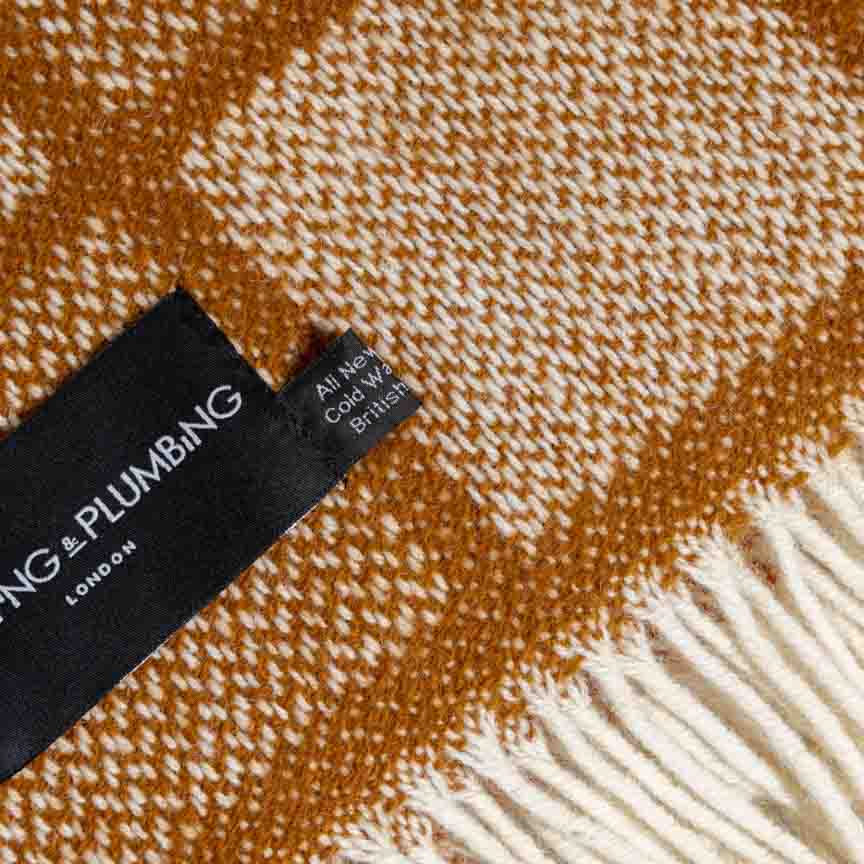 British Blanket with heating and plumbing brand label on a herringbone patterned