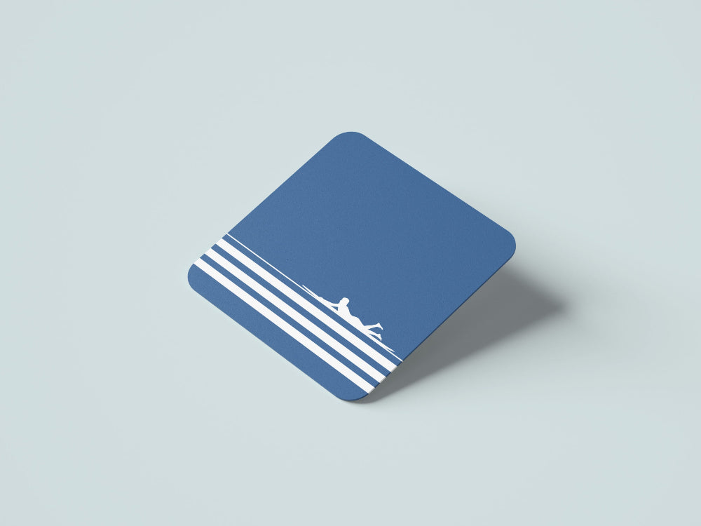 Blue coaster with white stripes and surfer on wave on a light grey background
