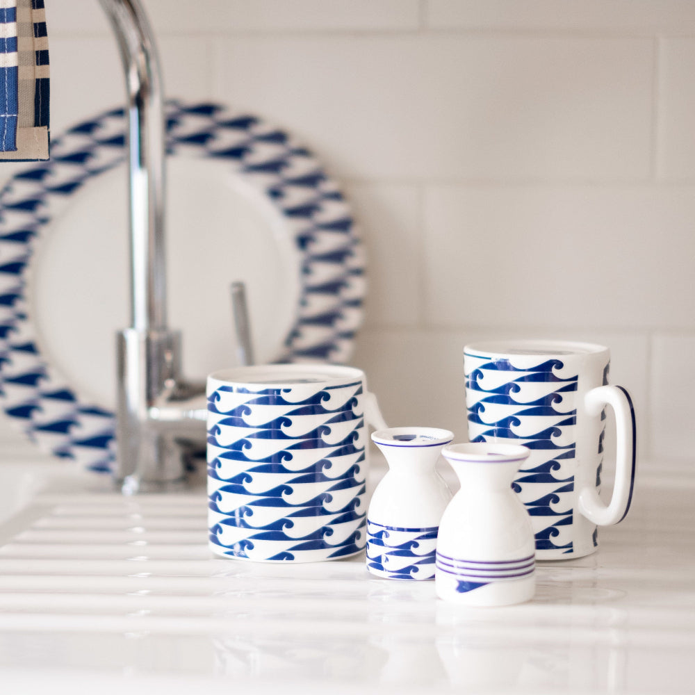 Set of blue and white patterned mugs and a pitcher on a kitchen counter.