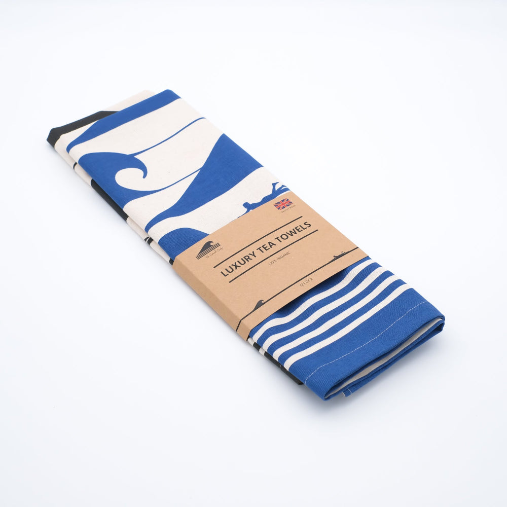 Packaged luxury tea towels with blue and white patterns on a white background