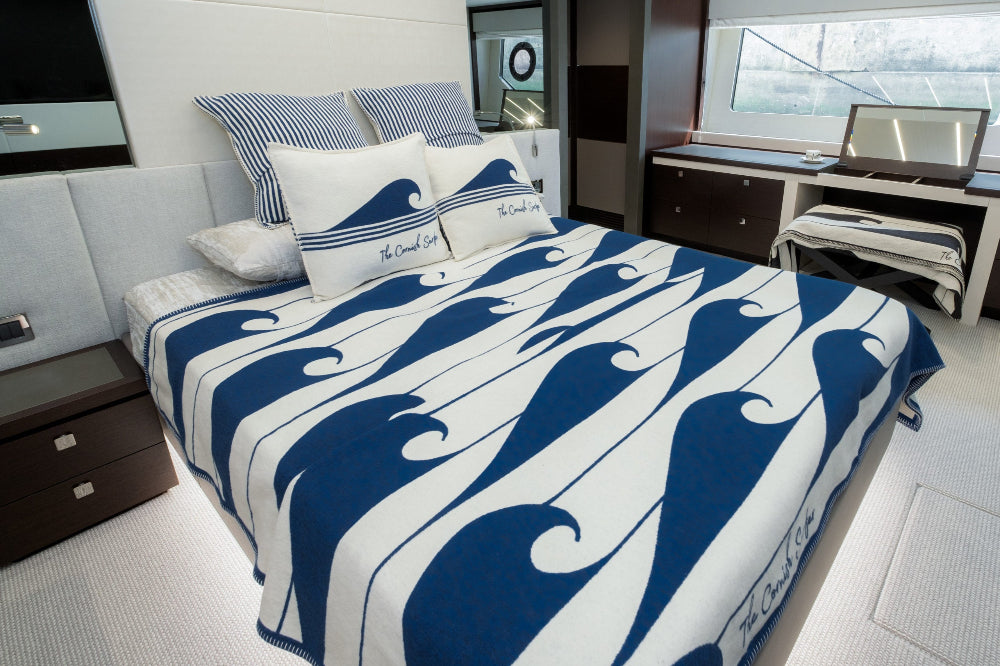 Bed with blue and white patterned comforter in a modern room setting.