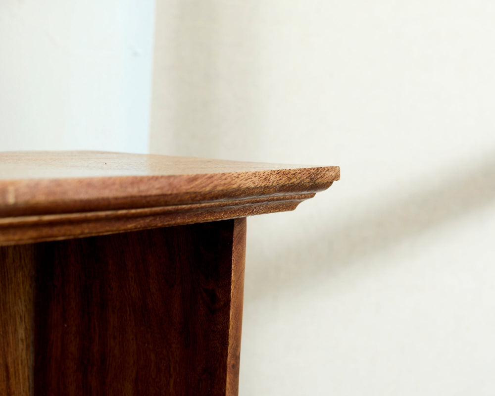 Wooden side table corner with a plain white background