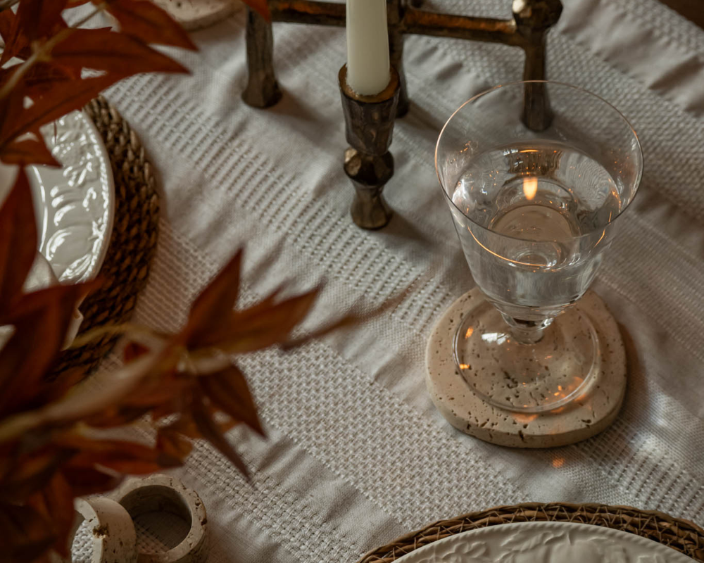 Glass of water on a textured tablecloth with decorative elements