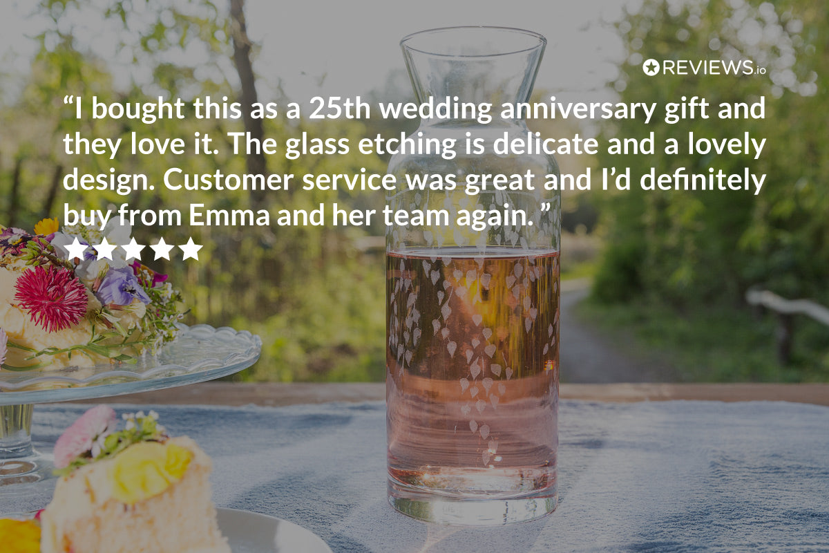 Glass Carafe with floral etching on a table outdoors, with a review text overlay.