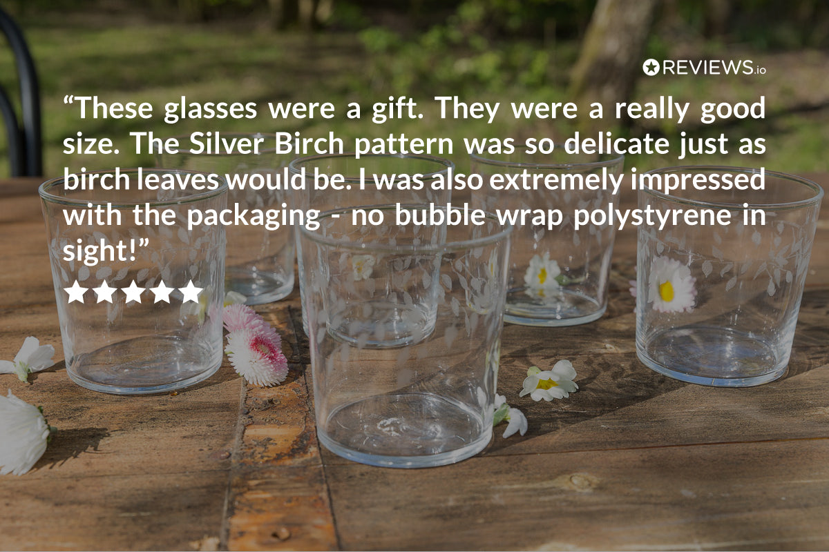 Clear glasses with floral design on a wooden surface, surrounded by flowers, with a five-star review text overlay.