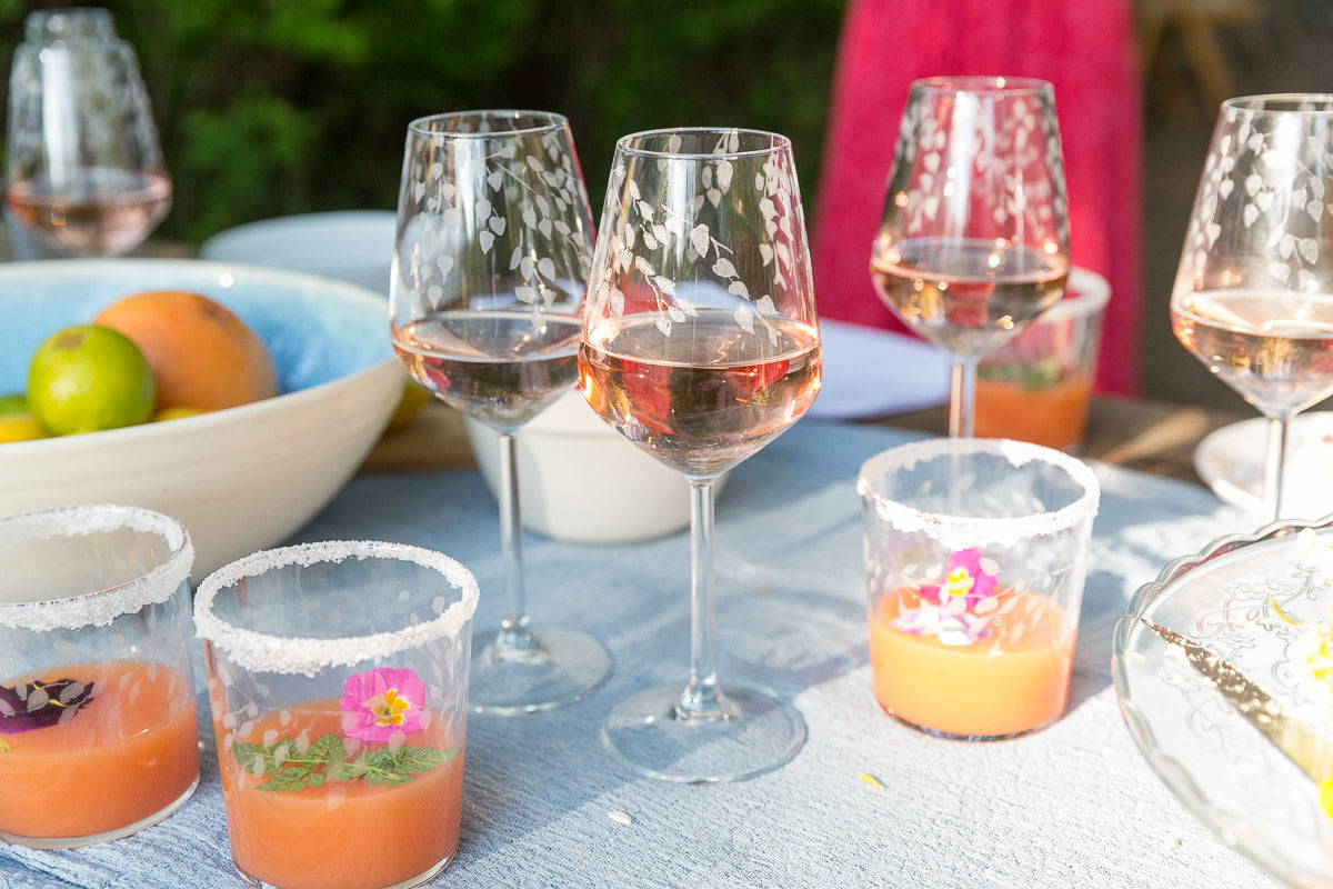 Outdoor setting with wine glasses and colorful drinks on a table
