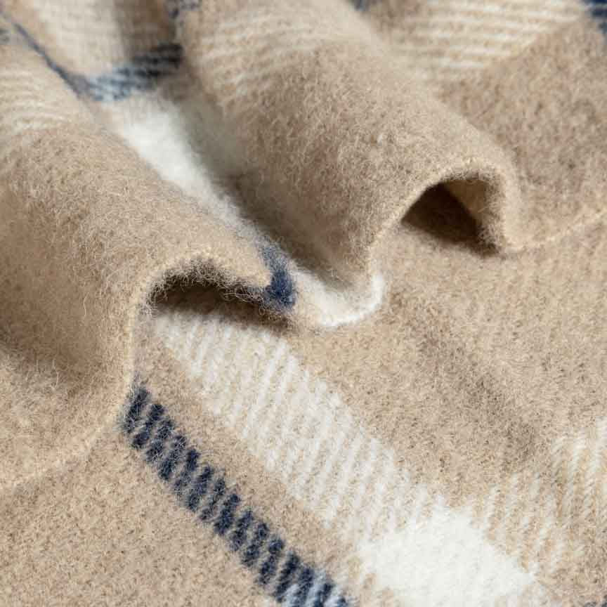 Close-up of beige and blue plaid fabric blanket