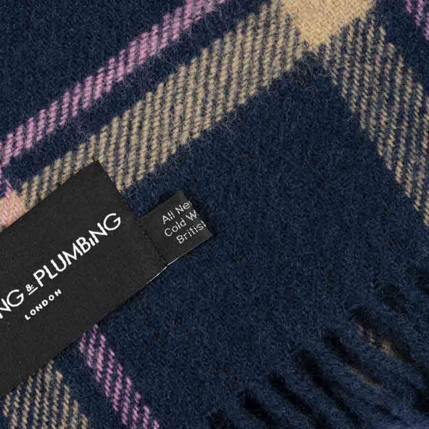 Close-up of a checkered fabric with a brand tag on a dark blue background