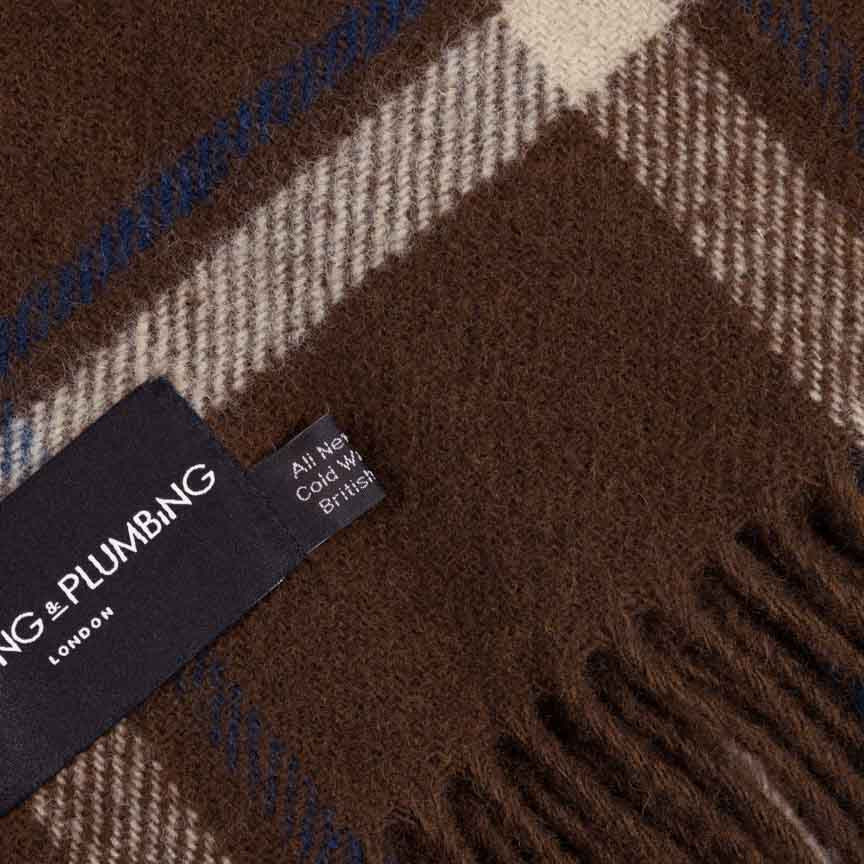 Brown checkered scarf with a brand tag on a brown background