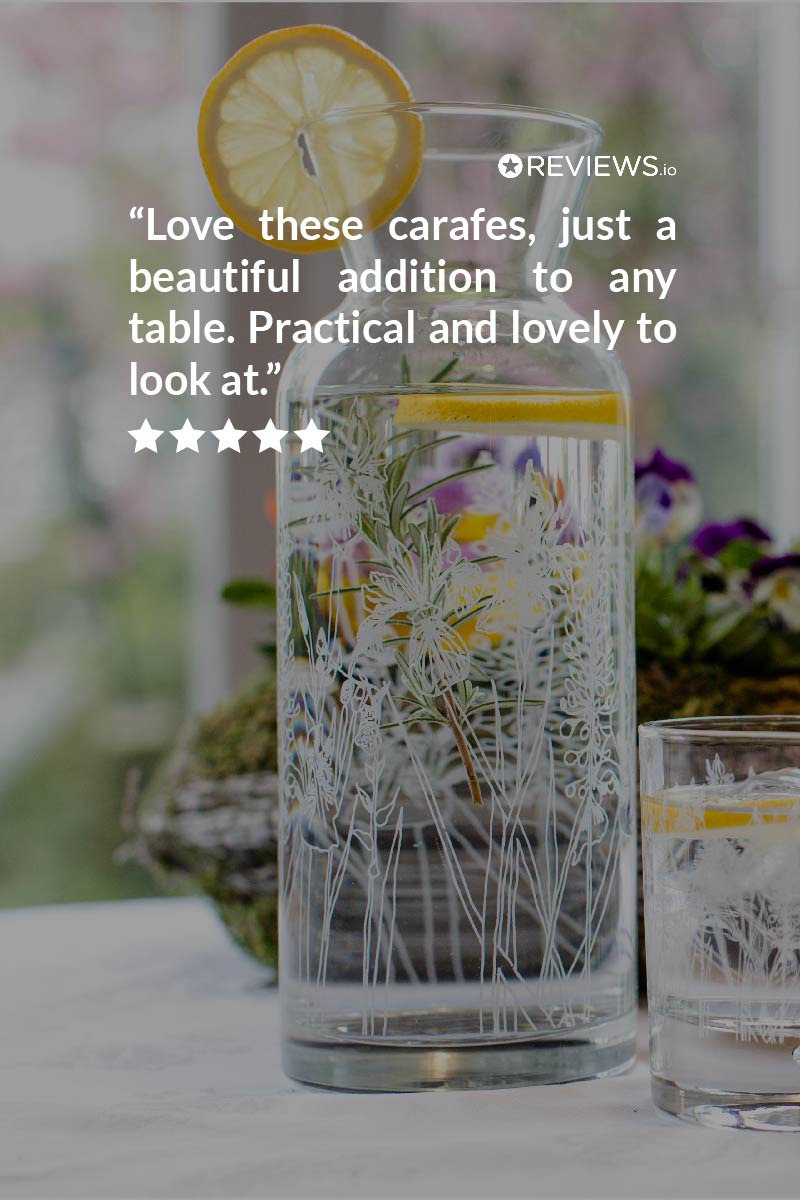 Decorative glass carafe with floral design on a table, with a quote overlay.