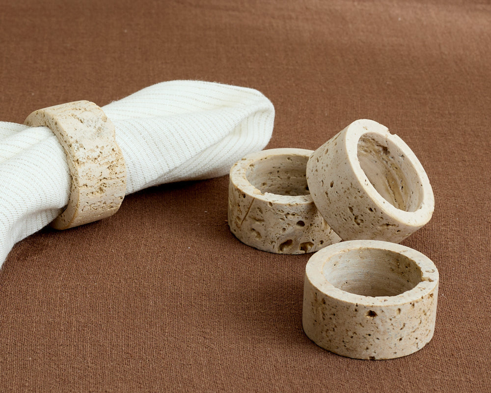 Set of stone-like travertine napkin rings on a brown surface
