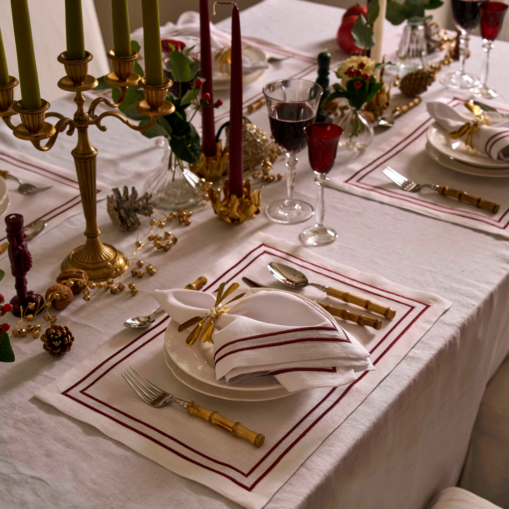 Elegant Christmas table setting with gold accents and red candles.