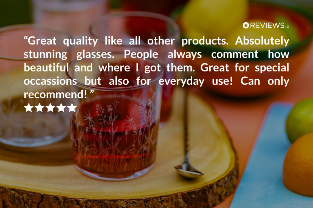 Glass of red liquid on a wooden coaster with a review text overlay