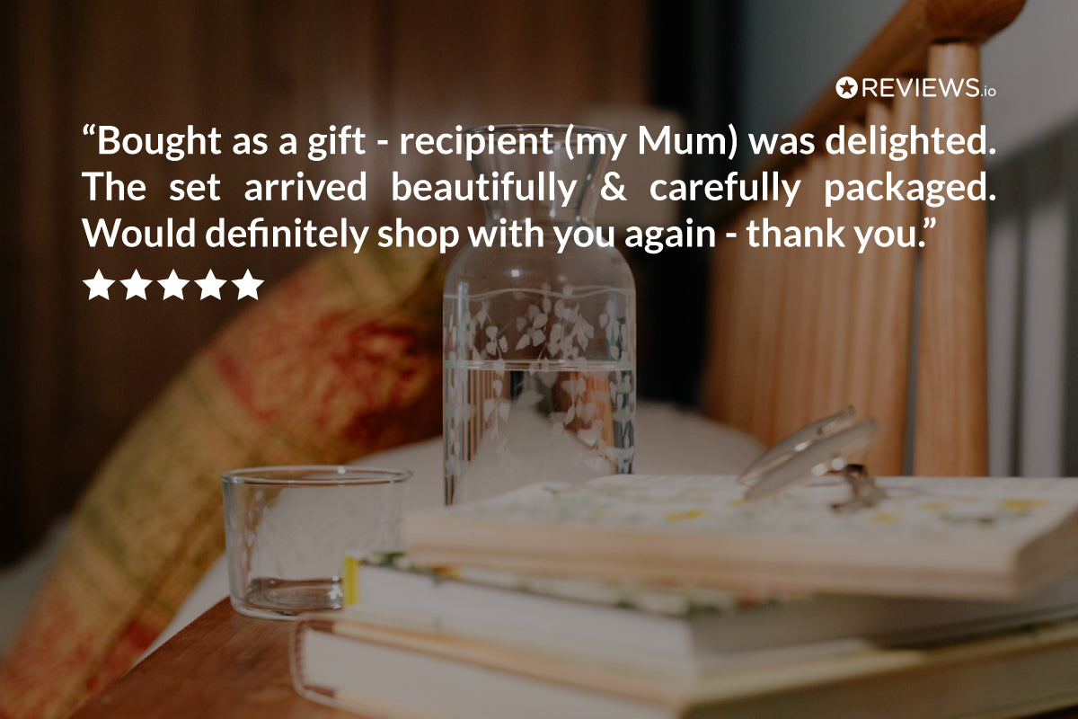 Glass set on books with a five-star review text overlay