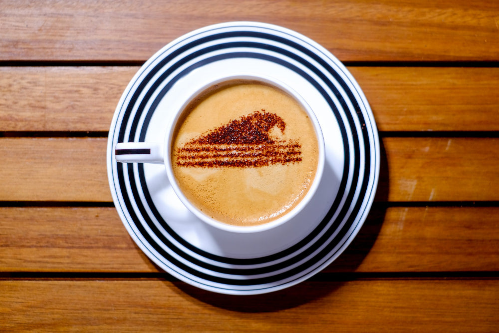 Cup of coffee with chocolate sprinkes with a decorative pattern on a wooden surface