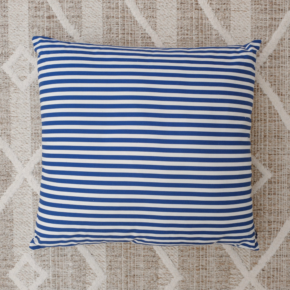 Blue and white striped pillow on a textured beige and white background