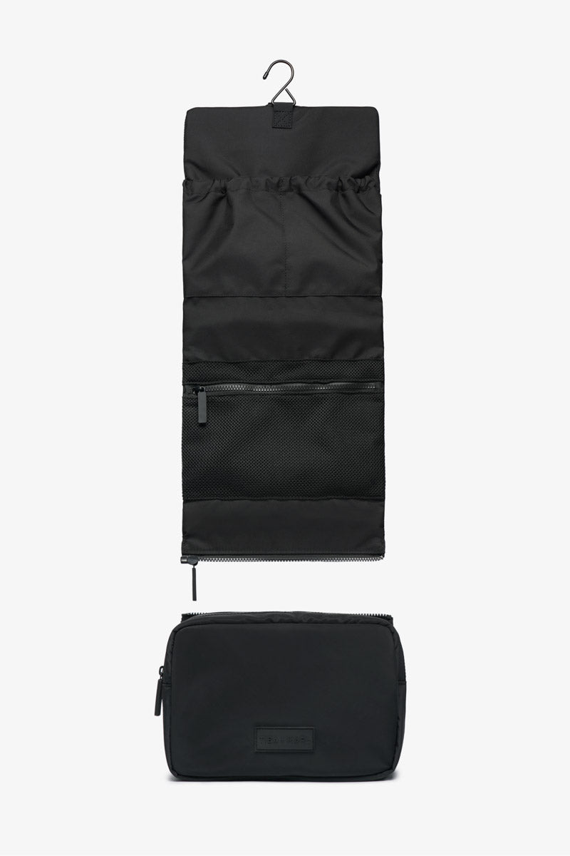 Black travel organizer with hanging and flat compartments on a white background