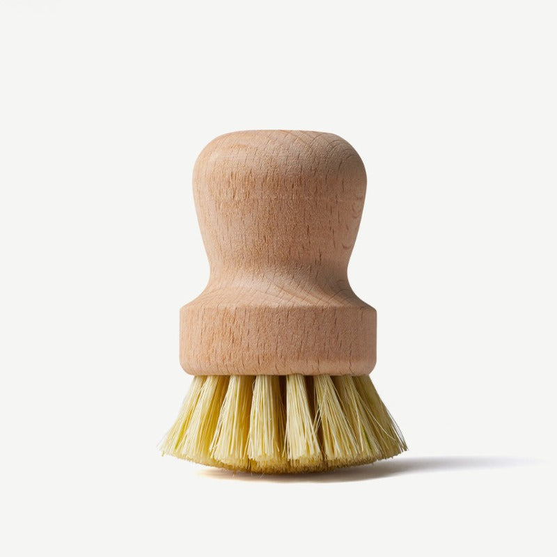 Wooden dish brush with yellow bristles on a white background