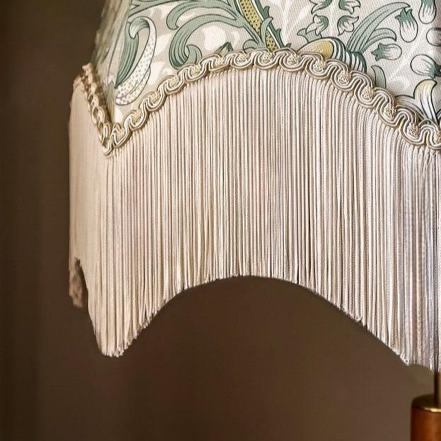 Close-up of a decorative lampshade with fringes and intricate patterns.