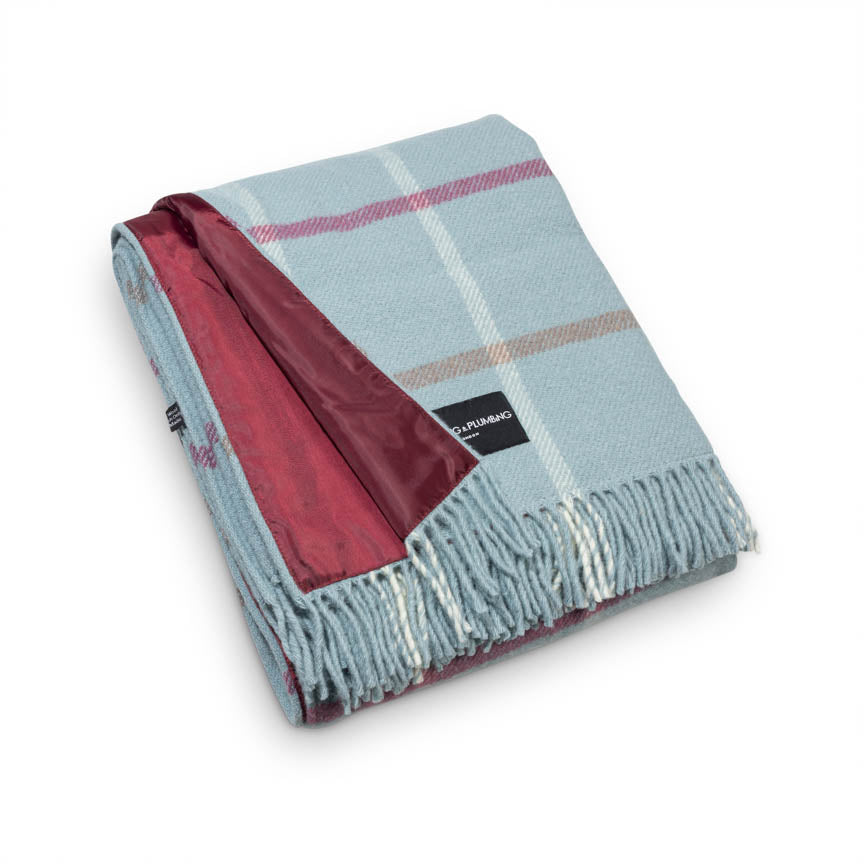Plaid blanket with red interior and visible brand logo on a white background