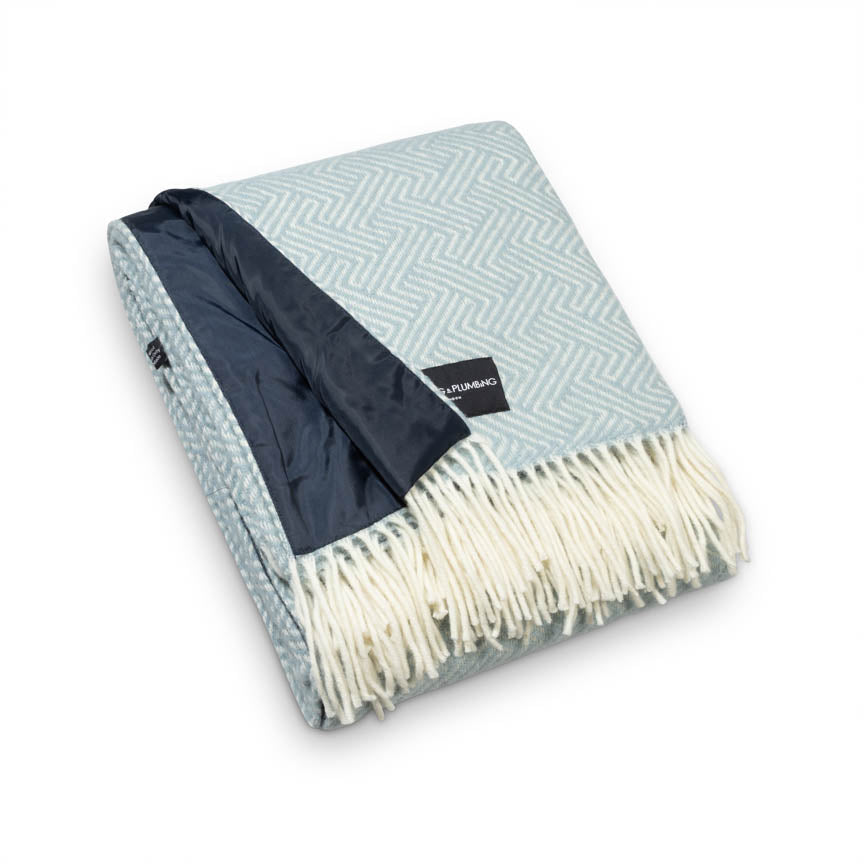Folded duck egg coloured blanket with waterproof backing.