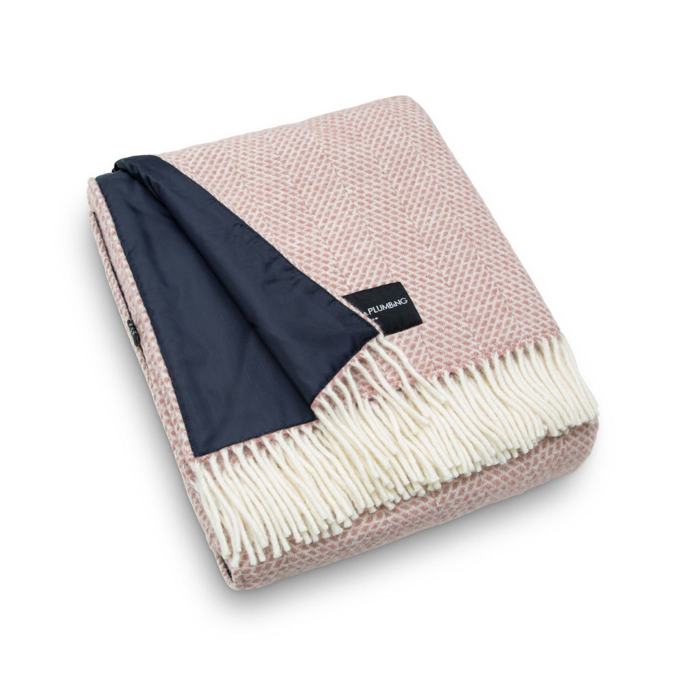 Pink and navy blanket with white fringe on a white background