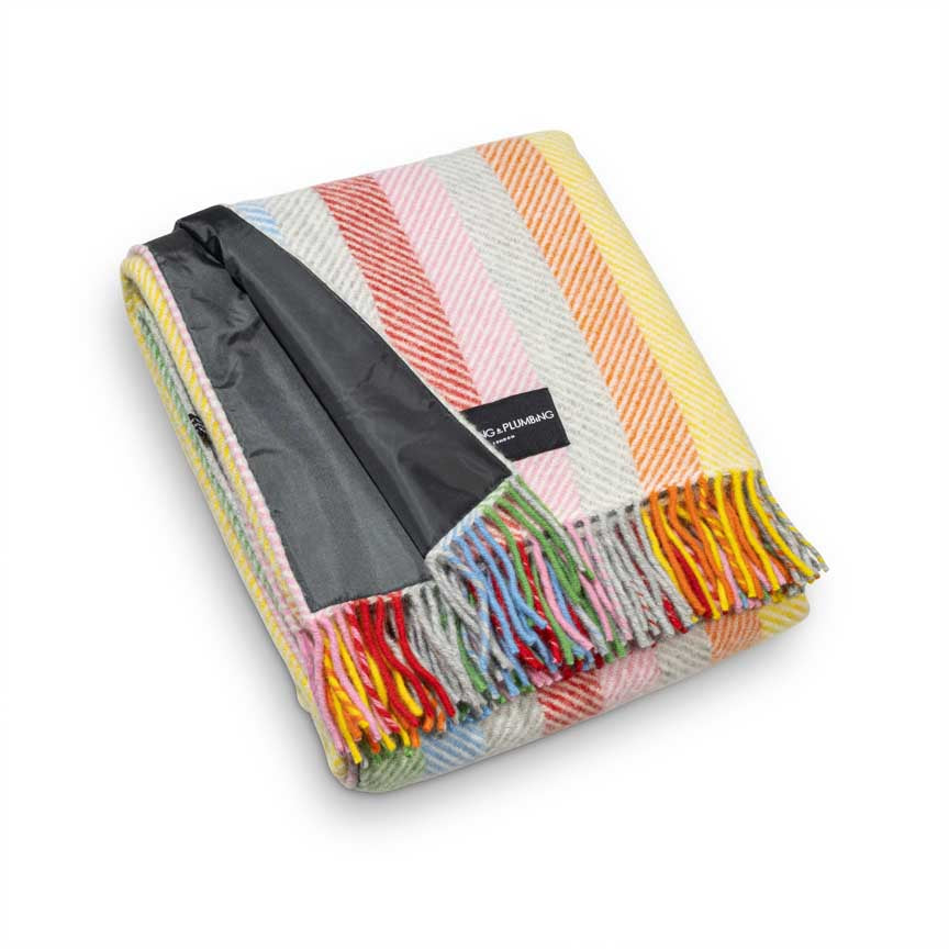 Colourful striped blanket with a black interior and brand label on a white background