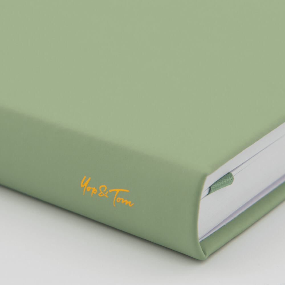 Yop and Tom Sage Green Spined notebook with 'Yop & Tom' embroidery on a light grey background