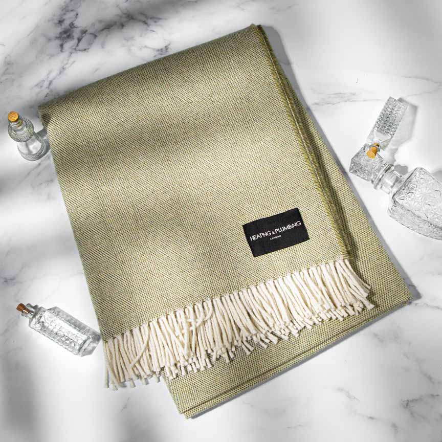Green blanket with a brand label on a marble surface
