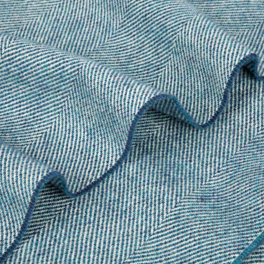 Close-up of blue blanket with a herringbone pattern.