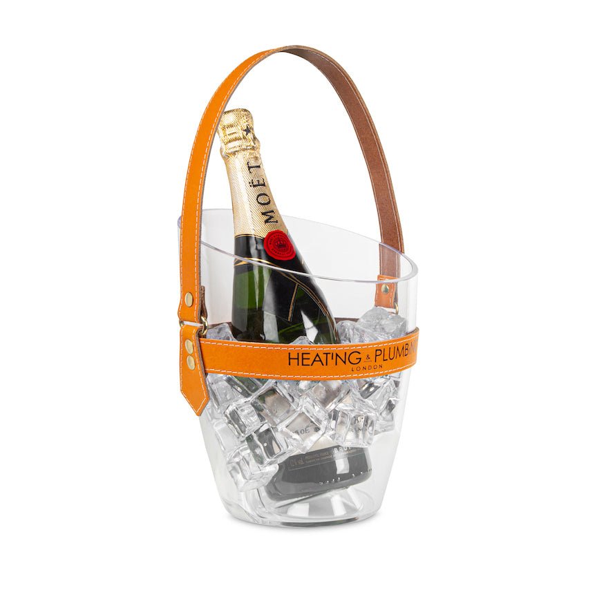 Clear ice bucket with orange handle holding a bottle of Moët & Chandon champagne on a white background.