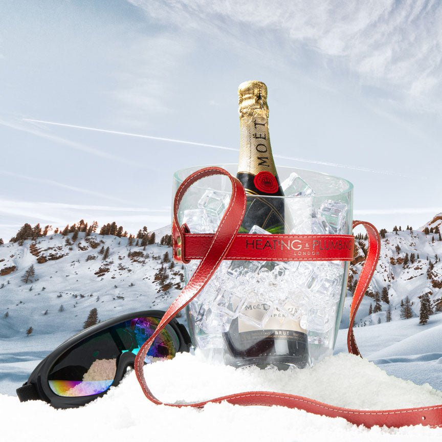 Bottle of Moët & Chandon champagne in an ice bucket with sunglasses on a snowy background