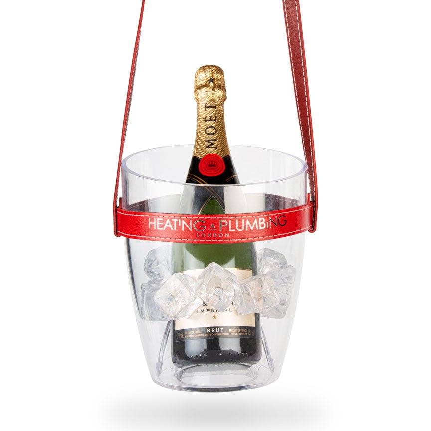 Clear ice bucket with red handle holding a bottle of Moët & Chandon champagne on a white background