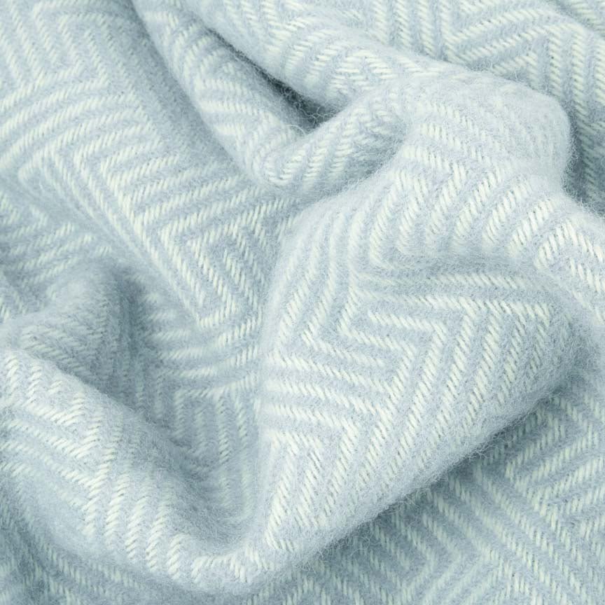 Close-up of a light blue blanket with a herringbone pattern