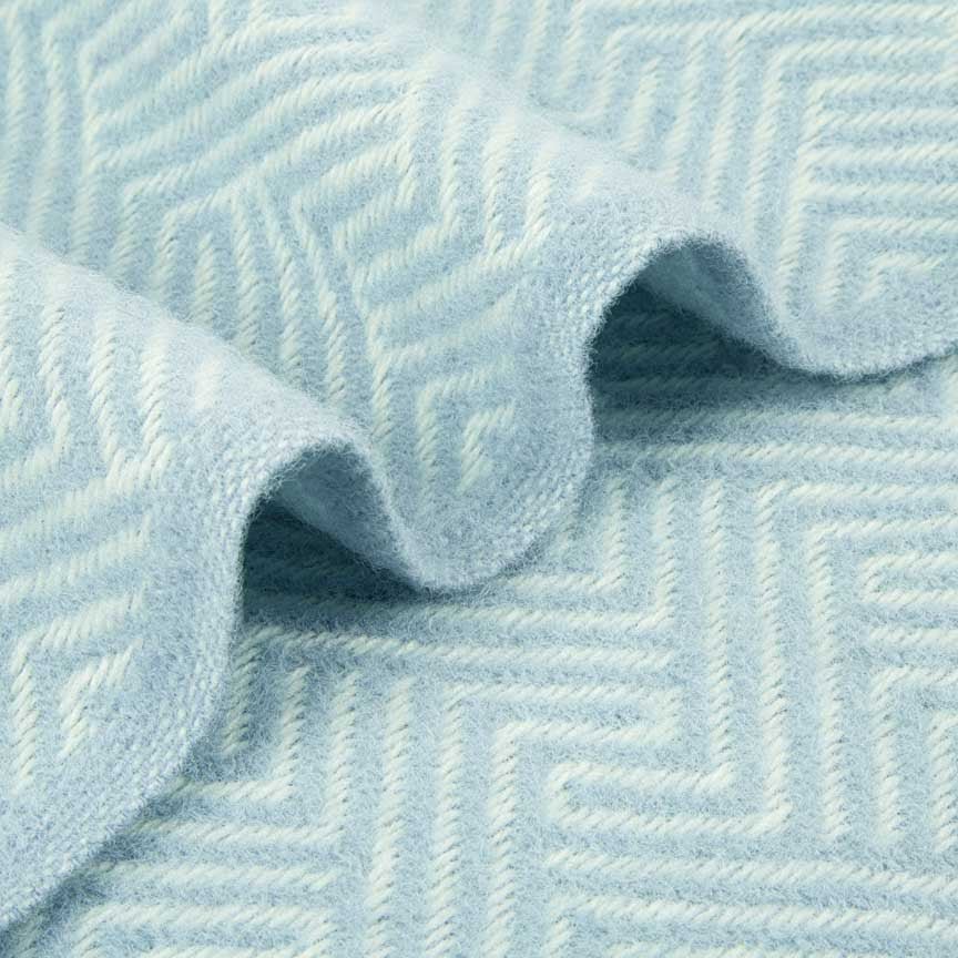 Close-up of textured light blue blanket with a geometric pattern