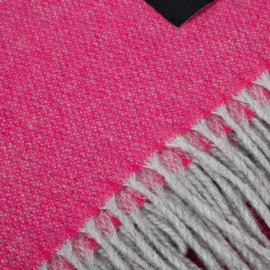 Close-up of a pink and grey blanket with fringes