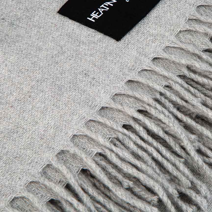 Grey cashmere blanket with a brand label in the corner 'Heating and Plumbing'