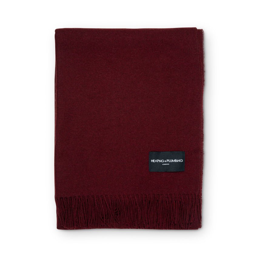 Burgundy blanket with a brand label on a white background