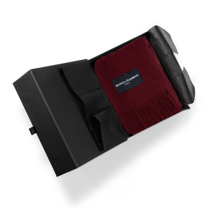 Black box with a red scarf blanket, featuring a brand label 'Heating and Plumbing' on a white background.