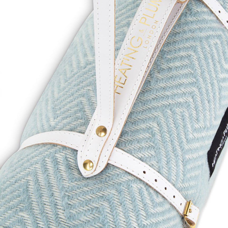 Close-up of duck egg blanket with a white strap and gold accents.