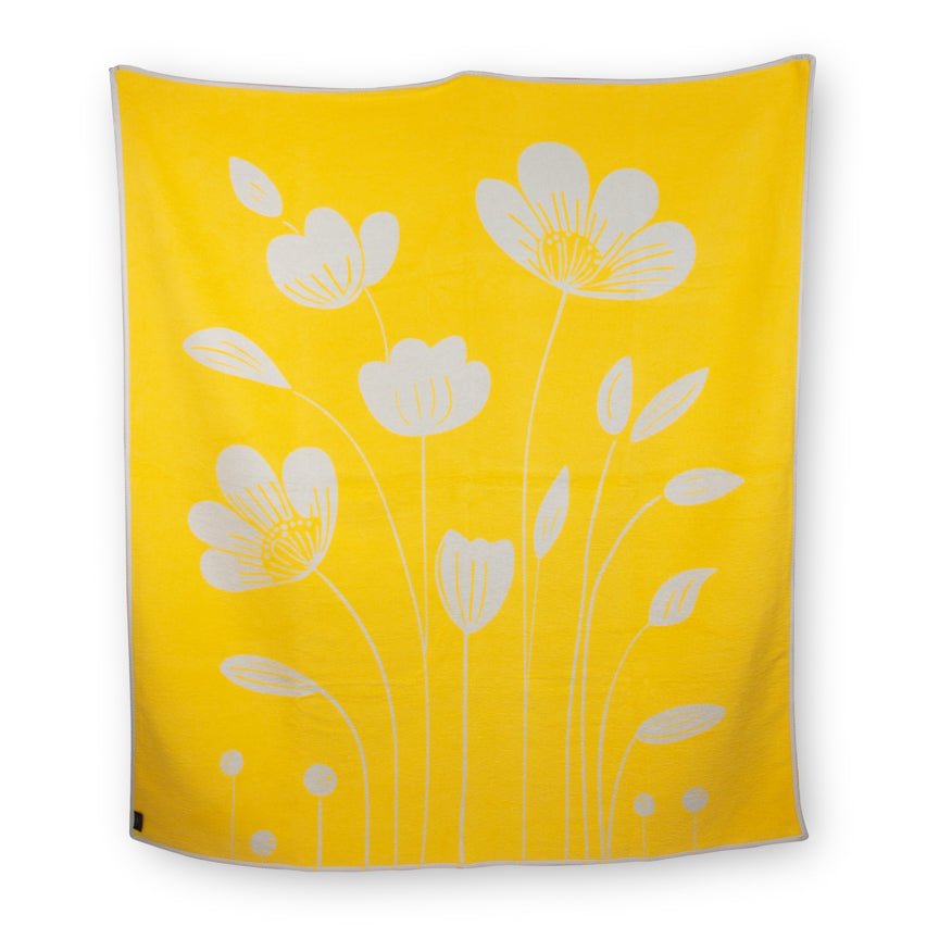 Yellow blanket with white floral patterns on a white background