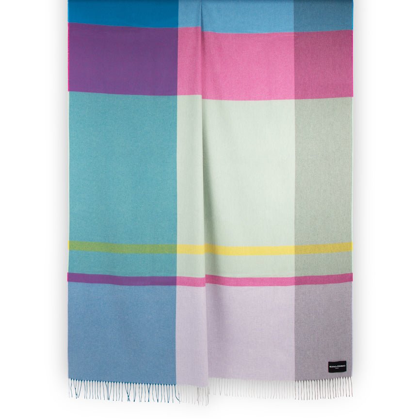 Colourful plaid blanket with a brand label on a white background