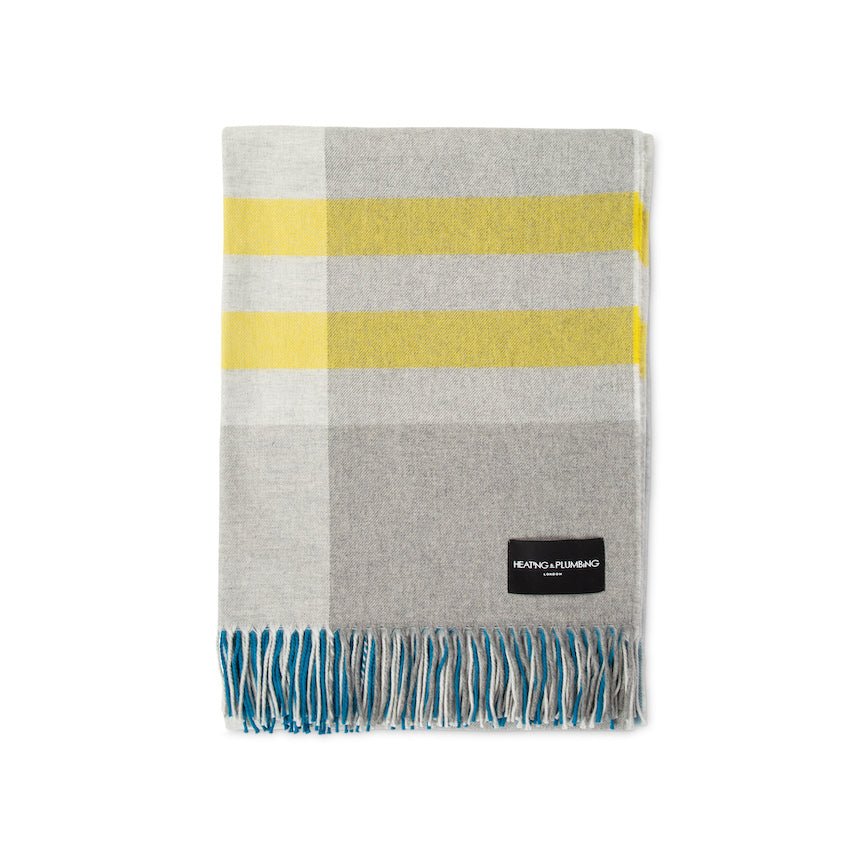 Plaid blanket with grey, yellow, and white stripes on a white background