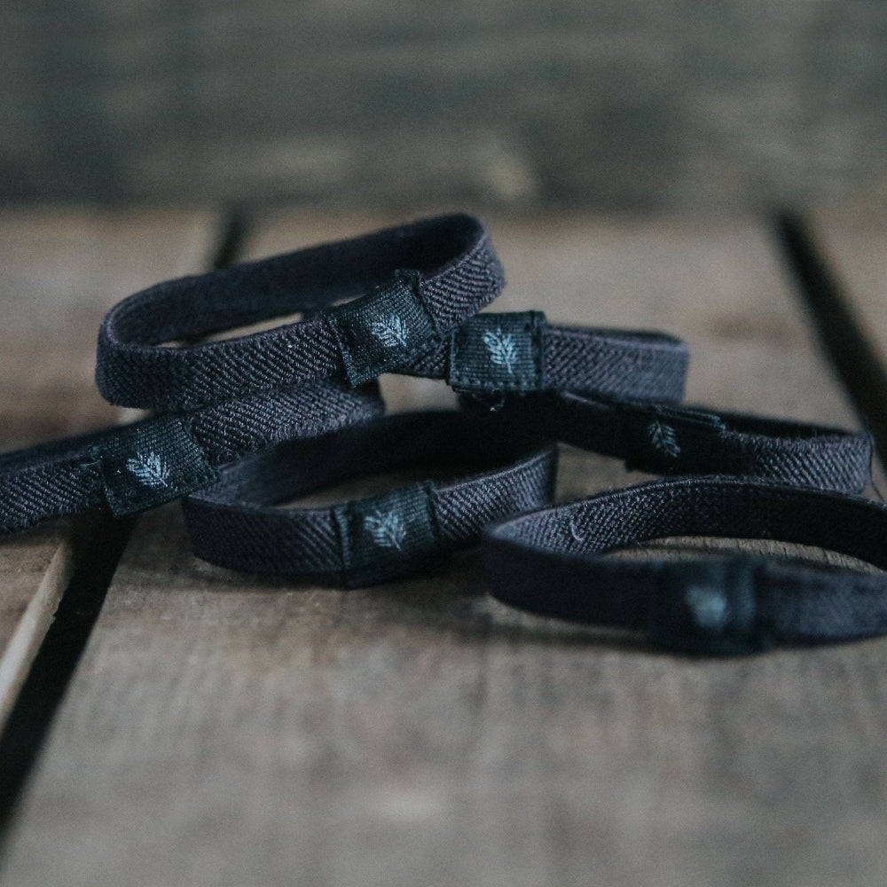 Black plastic free hair ties on a wooden surface
