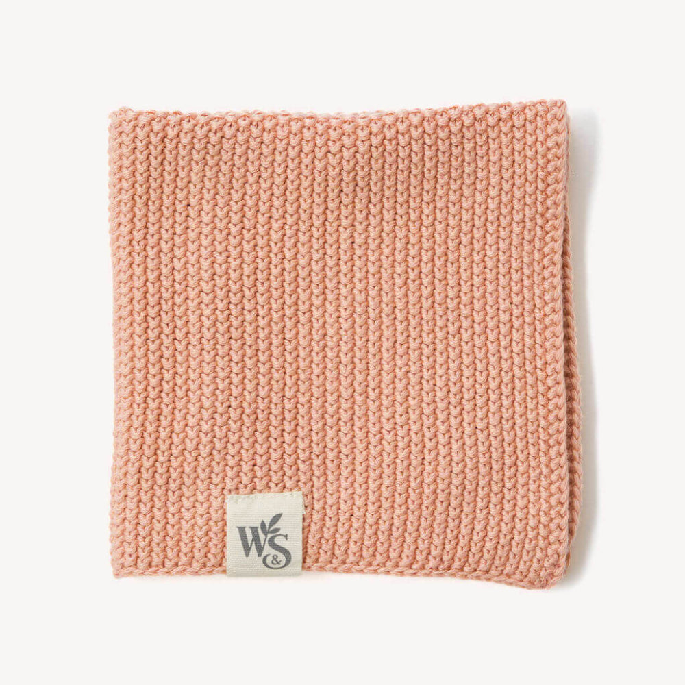 Blush Pink knitted organic dishcloth with a logo on a white background